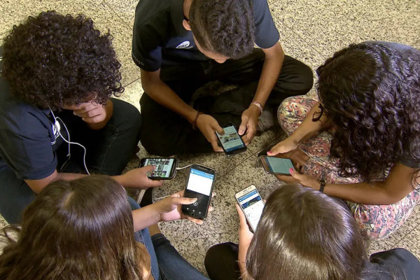 Adolescentes utilizando aparelho celular