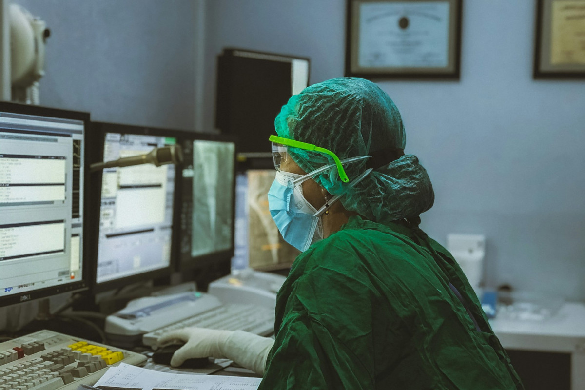 Médico olhando computador. 
