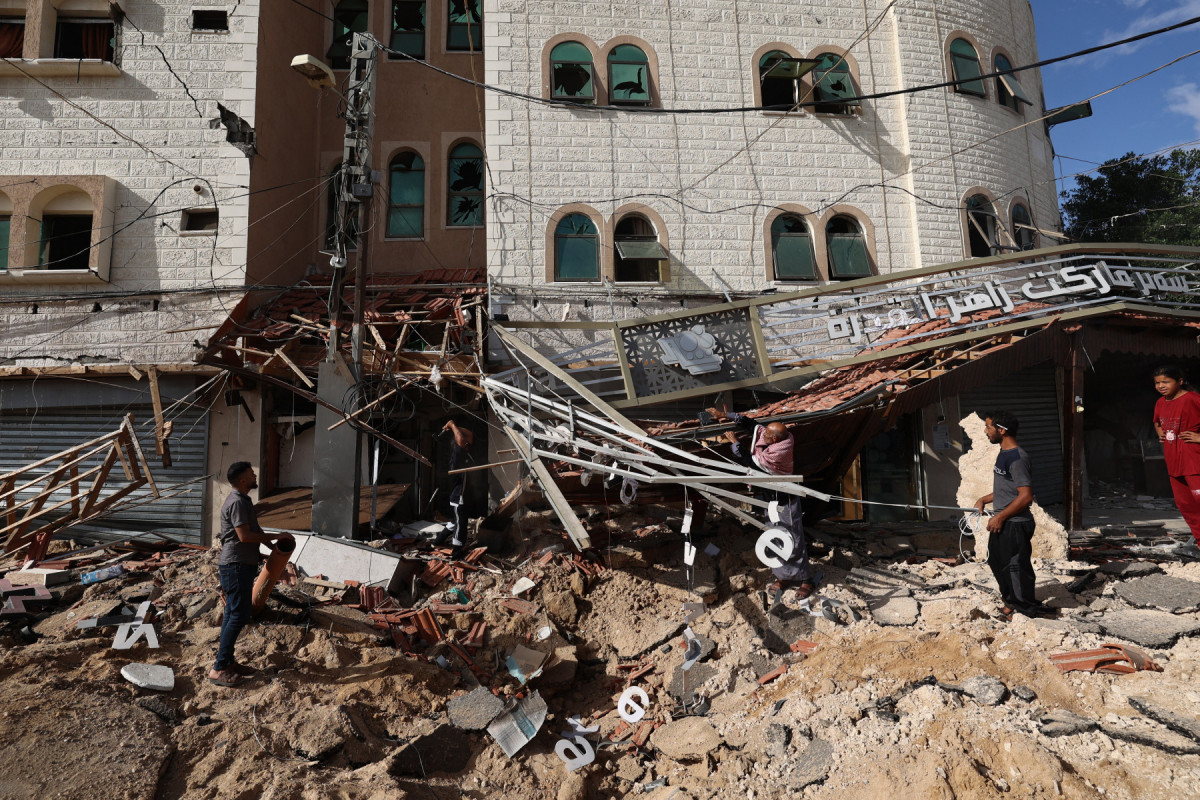 Pessoas verificam as consequências de um ataque israelense em Khan Yunis, no sul da Faixa de Gaza