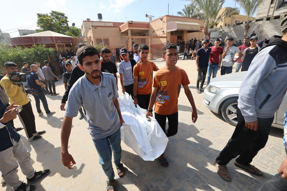 Pessoas em luto carregam um corpo durante o cortejo fúnebre das vítimas de um ataque israelense em Khan Yunis, no sul da Faixa de Gaza