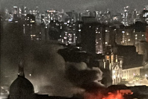 O fogo ameaça se espalhar para um prédio ao lado. Os bombeiros estão no local