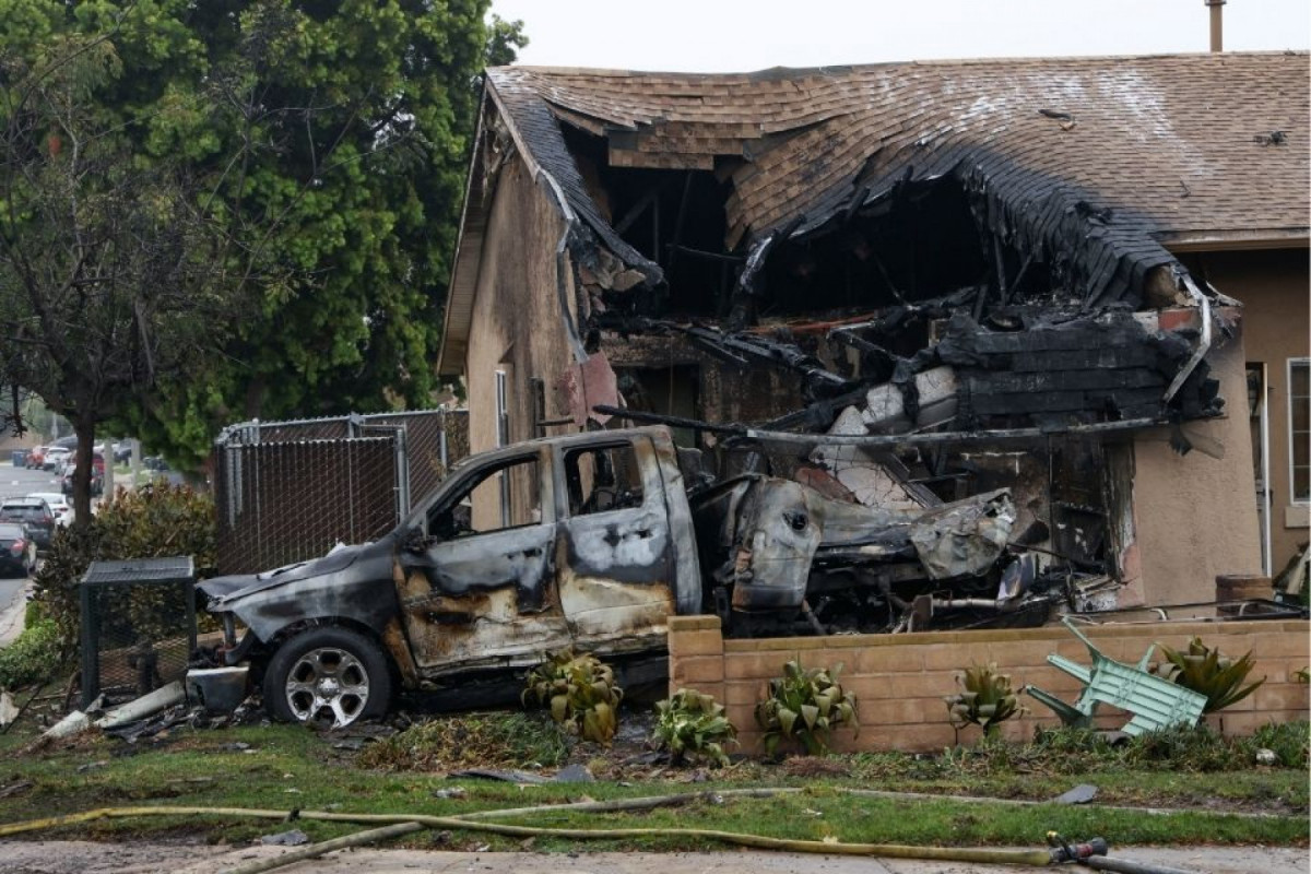 Destroços da aeronave que atingiu casa e carros (SANDY HUFFAKER/AFP) Destroços da aeronave que atingiu casa e carros /SANDY HUFFAKER/AFP