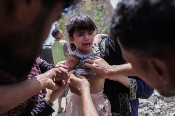 Palestinos cuidam de uma menina ferida em um ataque israelense no bairro de Saftawi, a oeste de Jabalia, no norte da Faixa de Gaza, em 27 de maio de 2025.