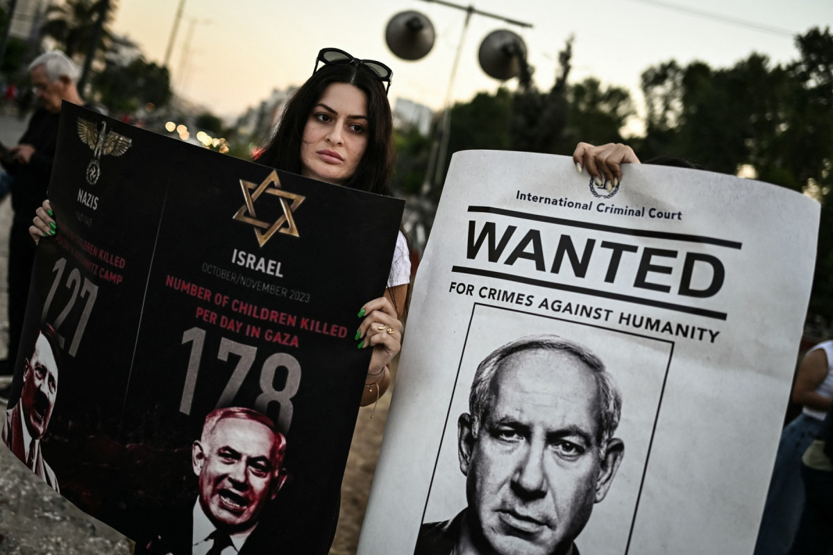Manifestantes seguram faixas durante uma manifestação em apoio ao povo palestino em frente à embaixada israelense em Atenas, em 22 de maio de 2025.