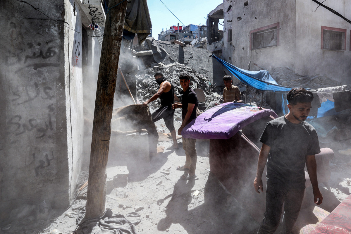 Pessoas recuperam itens das ruínas de um prédio danificado após o bombardeio israelense no campo de refugiados palestinos de Bureij, no centro da Faixa de Gaza, em 23 de maio de 2025. A agência de defesa civil de Gaza informou que ataques israelenses mataram pelo menos 16 pessoas em todo o território palestino em 23 de maio, onde Israel intensificou sua ofensiva militar nos últimos dias. Israel havia retomado grandes operações em Gaza em 18 de março, encerrando um cessar-fogo de dois meses. (Foto: Eyad BABA / AFP) Pessoas recuperam itens das ruínas de um prédio danificado após o bombardeio israelense no campo de refugiados palestinos de Bureij, no centro da Faixa de Gaza, em 23 de maio de 2025. A agência de defesa civil de Gaza informou que ataques israelenses mataram pelo menos 16 pessoas em todo o território palestino em 23 de maio, onde Israel intensificou sua ofensiva militar nos últimos dias. Israel havia retomado grandes operações em Gaza em 18 de março, encerrando um cessar-fogo de dois meses./Foto: Eyad BABA / AFP