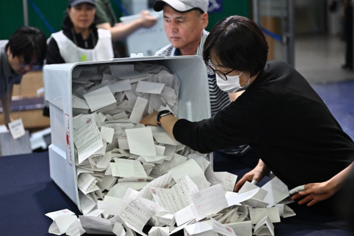 Autoridades eleitorais descarregam uma urna em uma seção de apuração em Seul, em 3 de junho de 2025, após o encerramento da votação presidencial. (Pedro Pardo/AFP) Autoridades eleitorais descarregam uma urna em uma seção de apuração em Seul, em 3 de junho de 2025, após o encerramento da votação presidencial./Pedro Pardo/AFP