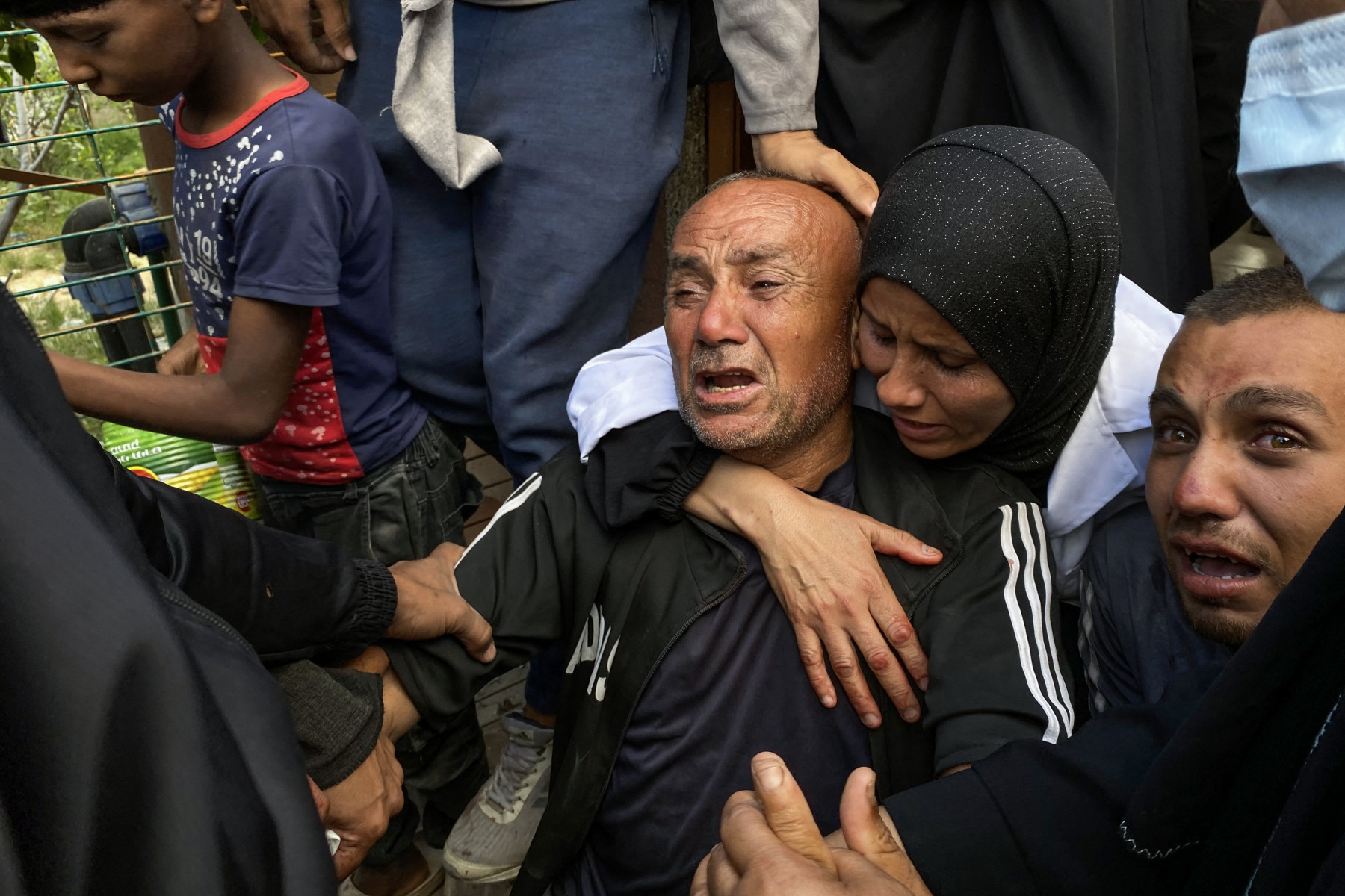 
Palestinos choram as mortes de parentes perto de um centro de distribuição de ajuda humanitária no sul de Gaza