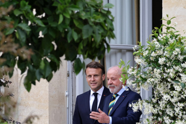 O presidente francês, Emmanuel Macron (E), e o presidente brasileiro, Luiz Inácio Lula da Silva, caminham após uma coletiva de imprensa conjunta após uma reunião no Palácio do Eliseu, em Paris,