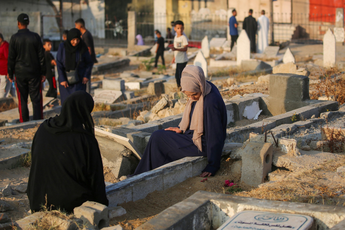 Palestinos visitam os túmulos de seus entes queridos no primeiro dia do festival muçulmano Eid al-Adha em Nuseirat, no centro da Faixa de Gaza, em 6 de junho de 2025, em meio à guerra entre Israel e o Hamas. (Foto de Eyad BABA / AFP)