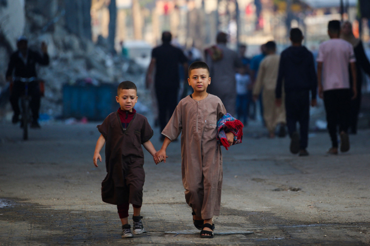 
Duas crianças saem após participarem de uma oração matinal especial no primeiro dia do festival muçulmano Eid al-Adha em Nuseirat, no centro da Faixa de Gaza, em 6 de junho de 2025, em meio à guerra entre Israel e o movimento militante Hamas. (Foto de Eyad BABA / AFP)