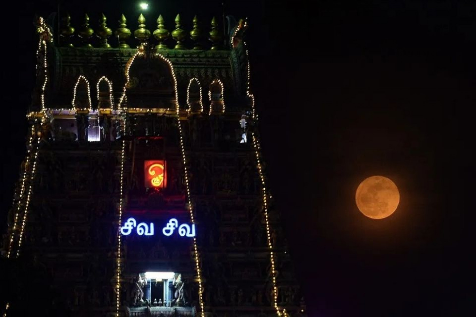 Lua de morango nascendo ao lado do templo de Kapaleeswarar, na Índia