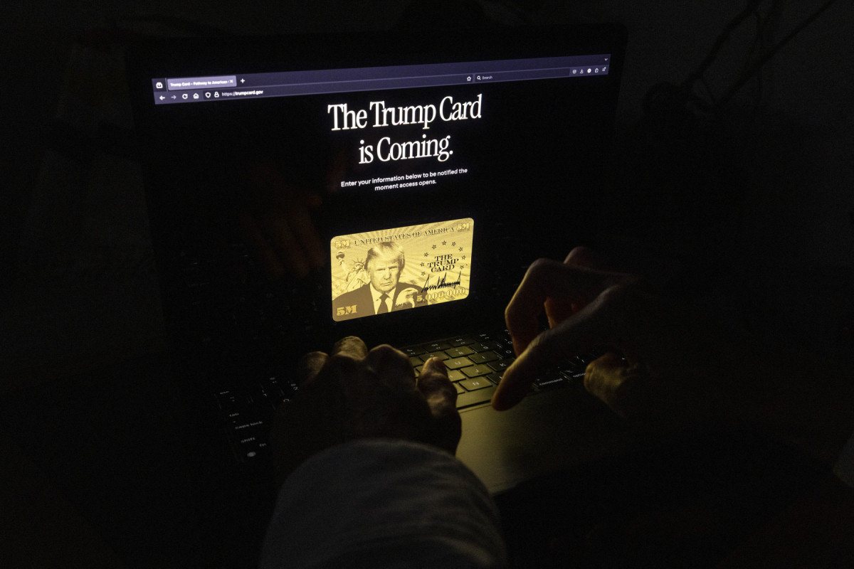 Esta foto ilustrativa, tirada em 11 de junho de 2025, mostra uma pessoa acessando o novo site para a autorização de residência americana de US$ 5 milhões em Los Angeles. O presidente Donald Trump divulgou um novo site para sua autorização de residência americana de US$ 5 milhões em 11 de junho, anunciando que a lista de espera para o visto dourado estava aberta no TrumpCard.gov. (Foto de ETIENNE LAURENT / AFP) ( AFP) Esta foto ilustrativa, tirada em 11 de junho de 2025, mostra uma pessoa acessando o novo site para a autorização de residência americana de US$ 5 milhões em Los Angeles. O presidente Donald Trump divulgou um novo site para sua autorização de residência americana de US$ 5 milhões em 11 de junho, anunciando que a lista de espera para o visto dourado estava aberta no TrumpCard.gov. (Foto de ETIENNE LAURENT / AFP)/ AFP