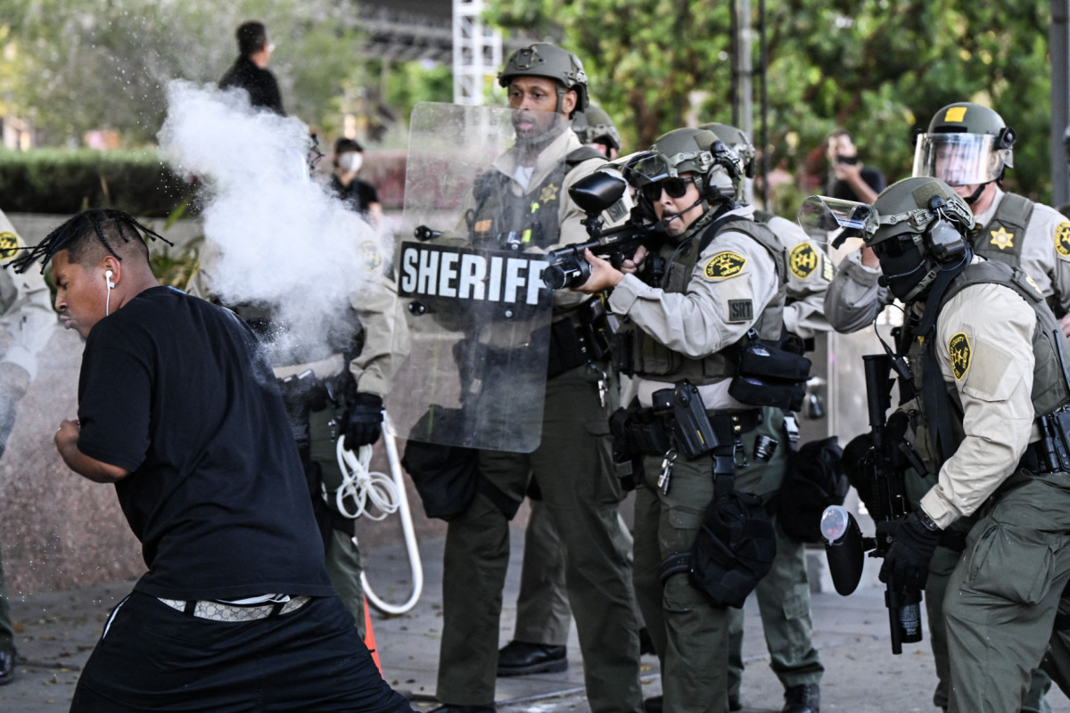 Policiais do Departamento do Xerife do Condado de Los Angeles disparam uma arma não letal contra um homem após ele atirar uma lata contra eles durante um protesto contra as operações federais de imigração perto da Prefeitura de Los Angeles, em 11 de junho de 2025. Protestos contra as duras políticas de imigração de Donald Trump se espalharam pelos Estados Unidos em 11 de junho, apesar da repressão apoiada pelos militares em Los Angeles e das ameaças do presidente republicano de extrema direita de usar Policiais do Departamento do Xerife do Condado de Los Angeles disparam uma arma não letal contra um homem após ele atirar uma lata contra eles durante um protesto contra as operações federais de imigração perto da Prefeitura de Los Angeles, em 11 de junho de 2025. Protestos contra as duras políticas de imigração de Donald Trump se espalharam pelos Estados Unidos em 11 de junho, apesar da repressão apoiada pelos militares em Los Angeles e das ameaças do presidente republicano de extrema direita de usar