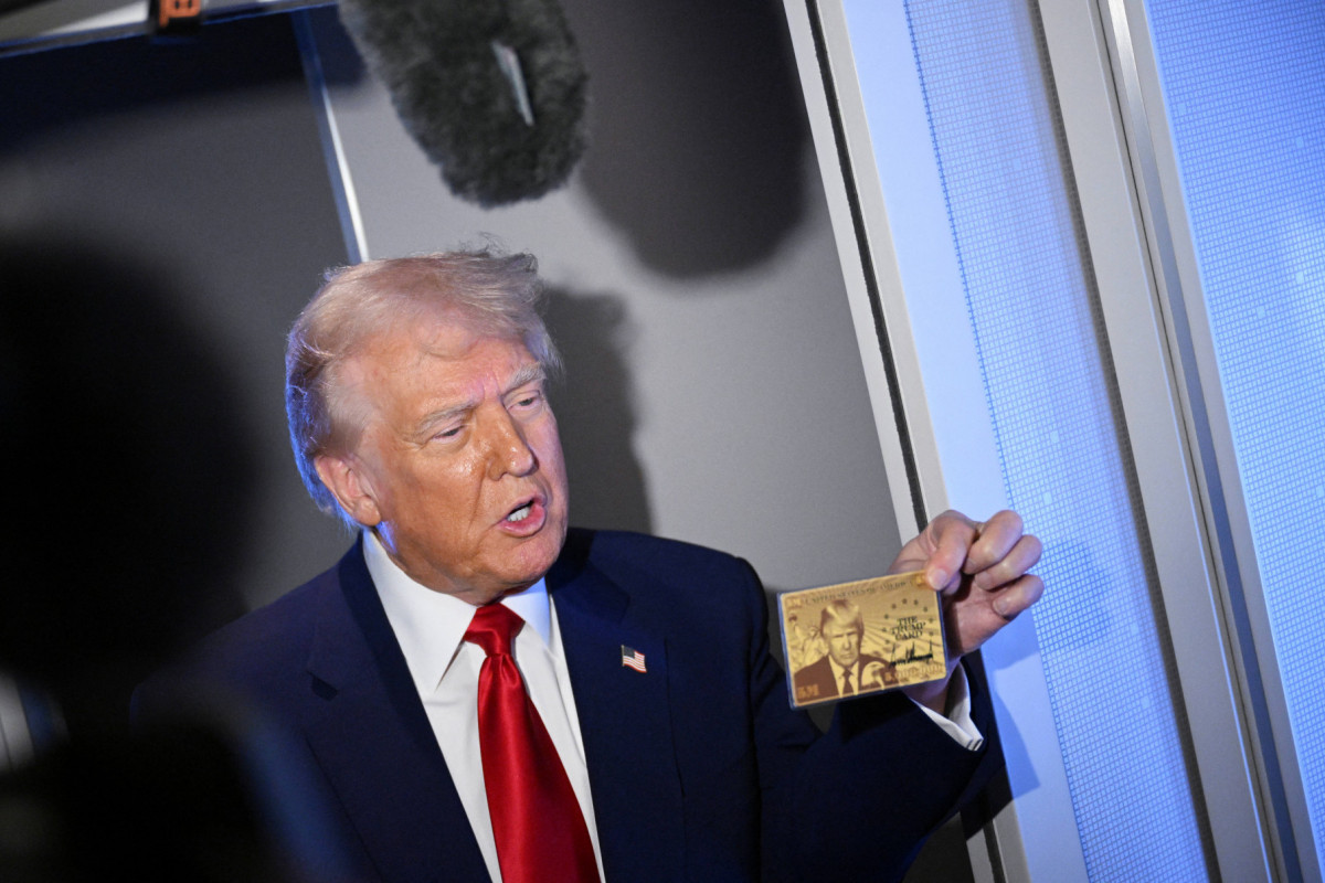 O presidente dos EUA, Donald Trump, segura o Gold Card de US$ 5 milhões enquanto fala com repórteres durante um voo a bordo do Air Force One, a caminho de Miami, Flórida, em 3 de abril de 2025. O presidente Donald Trump divulgou um novo site para sua autorização de residência americana de US$ 5 milhões, planejada para 11 de junho, informando que a lista de espera para o visto dourado foi aberta no TrumpCard.gov. (Foto de MANDEL NGAN / AFP)