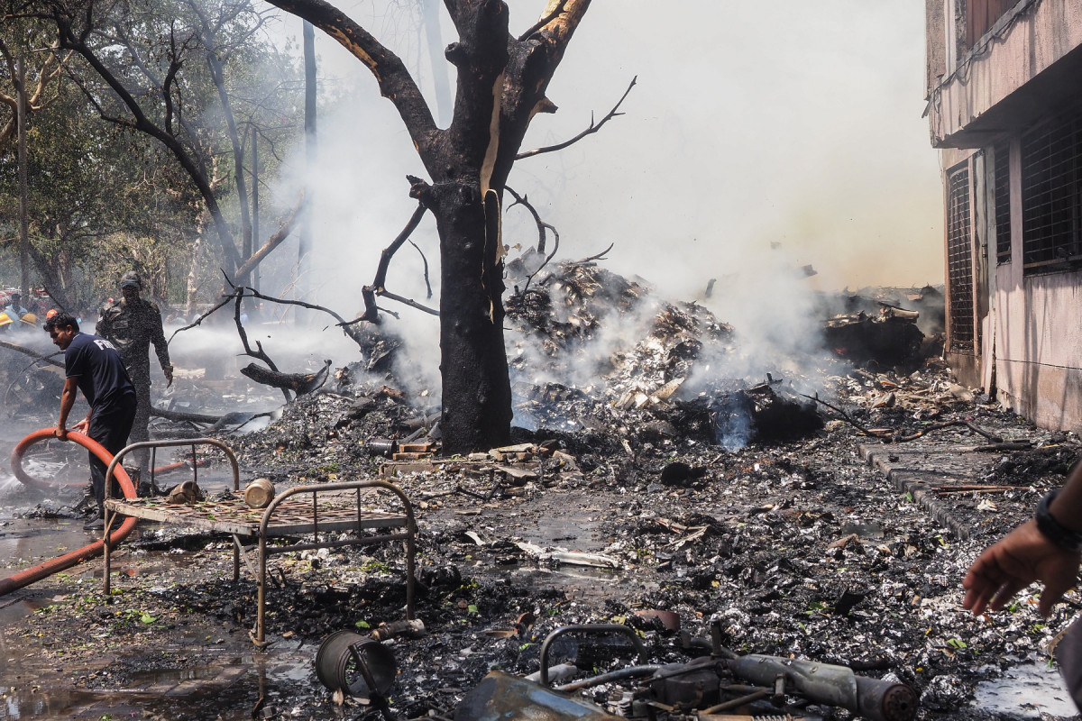 Bombeiros trabalham no local onde o voo 171 da Air India caiu em uma área residencial perto do aeroporto de Ahmedabad, em 12 de junho de 2025. O avião de passageiros com destino a Londres caiu em 12 de junho na cidade de Ahmedabad, no oeste da Índia, com 242 pessoas a bordo, disseram autoridades da aviação, no que a companhia aérea chamou de 