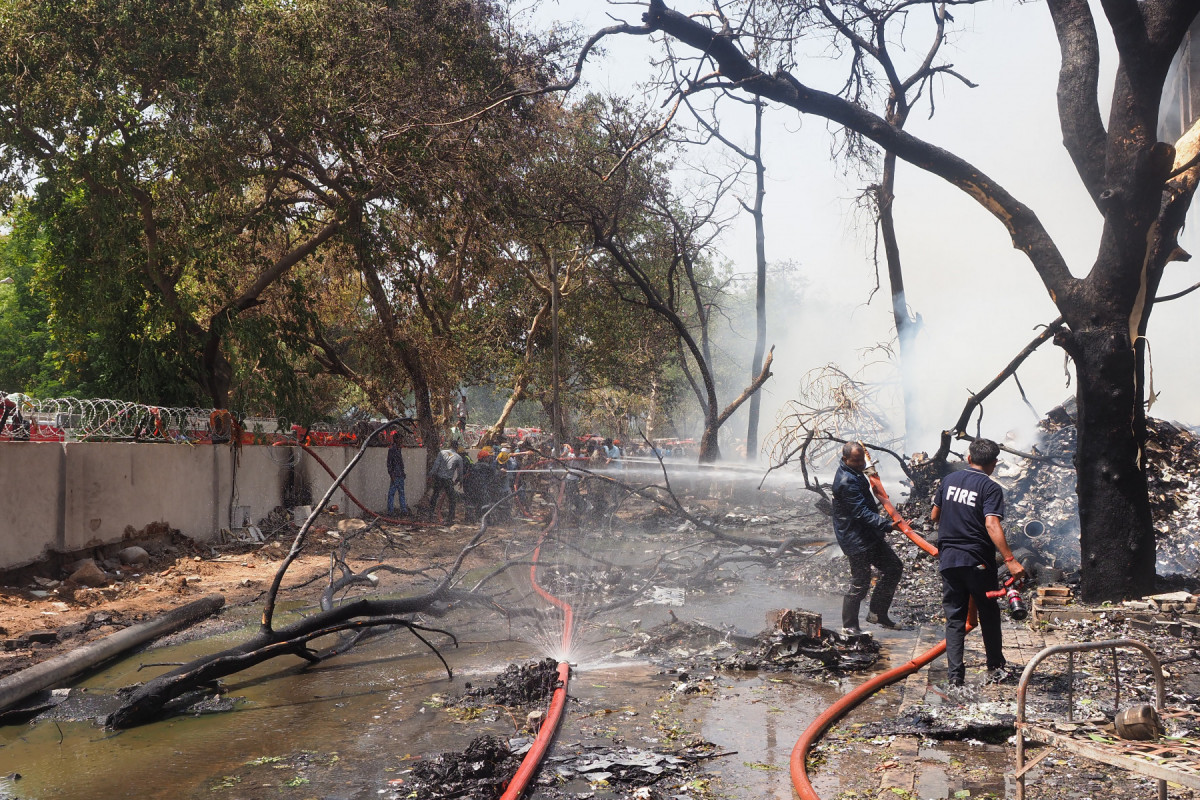Bombeiros trabalham no local onde o voo 171 da Air India caiu em uma área residencial perto do aeroporto de Ahmedabad, em 12 de junho de 2025. O avião de passageiros com destino a Londres caiu em 12 de junho na cidade de Ahmedabad, no oeste da Índia, com 242 pessoas a bordo, disseram autoridades da aviação, no que a companhia aérea chamou de 