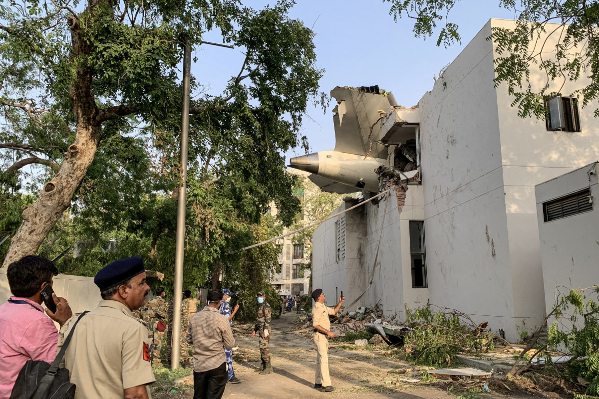A parte traseira do voo 171 da Air India é fotografada no local após a queda em uma área residencial perto do aeroporto de Ahmedabad em 12 de junho de 2025. Um avião de passageiros com destino a Londres caiu na cidade indiana de Ahmedabad na quinta-feira e acredita-se que todas as 242 pessoas a bordo morreram, com o jato colidindo com prédios que abrigavam médicos e suas famílias. (Foto de Sam PANTHAKY / AFP)