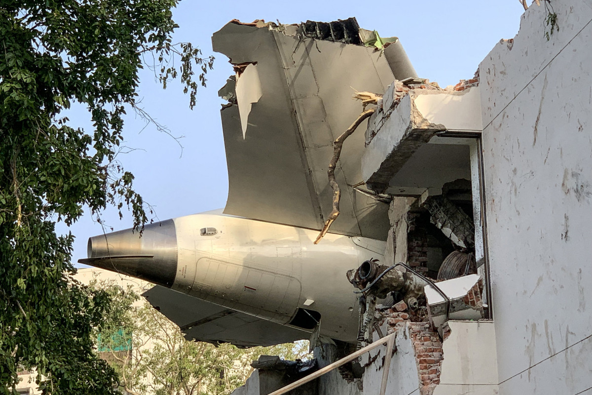 A parte traseira do voo 171 da Air India é fotografada no local após a queda em uma área residencial perto do aeroporto de Ahmedabad em 12 de junho de 2025. Um avião de passageiros com destino a Londres caiu na cidade indiana de Ahmedabad na quinta-feira e acredita-se que todas as 242 pessoas a bordo morreram, com o jato colidindo com prédios que abrigavam médicos e suas famílias. (Foto de Sam PANTHAKY / AFP) ( AFP) A parte traseira do voo 171 da Air India é fotografada no local após a queda em uma área residencial perto do aeroporto de Ahmedabad em 12 de junho de 2025. Um avião de passageiros com destino a Londres caiu na cidade indiana de Ahmedabad na quinta-feira e acredita-se que todas as 242 pessoas a bordo morreram, com o jato colidindo com prédios que abrigavam médicos e suas famílias. (Foto de Sam PANTHAKY / AFP)/ AFP