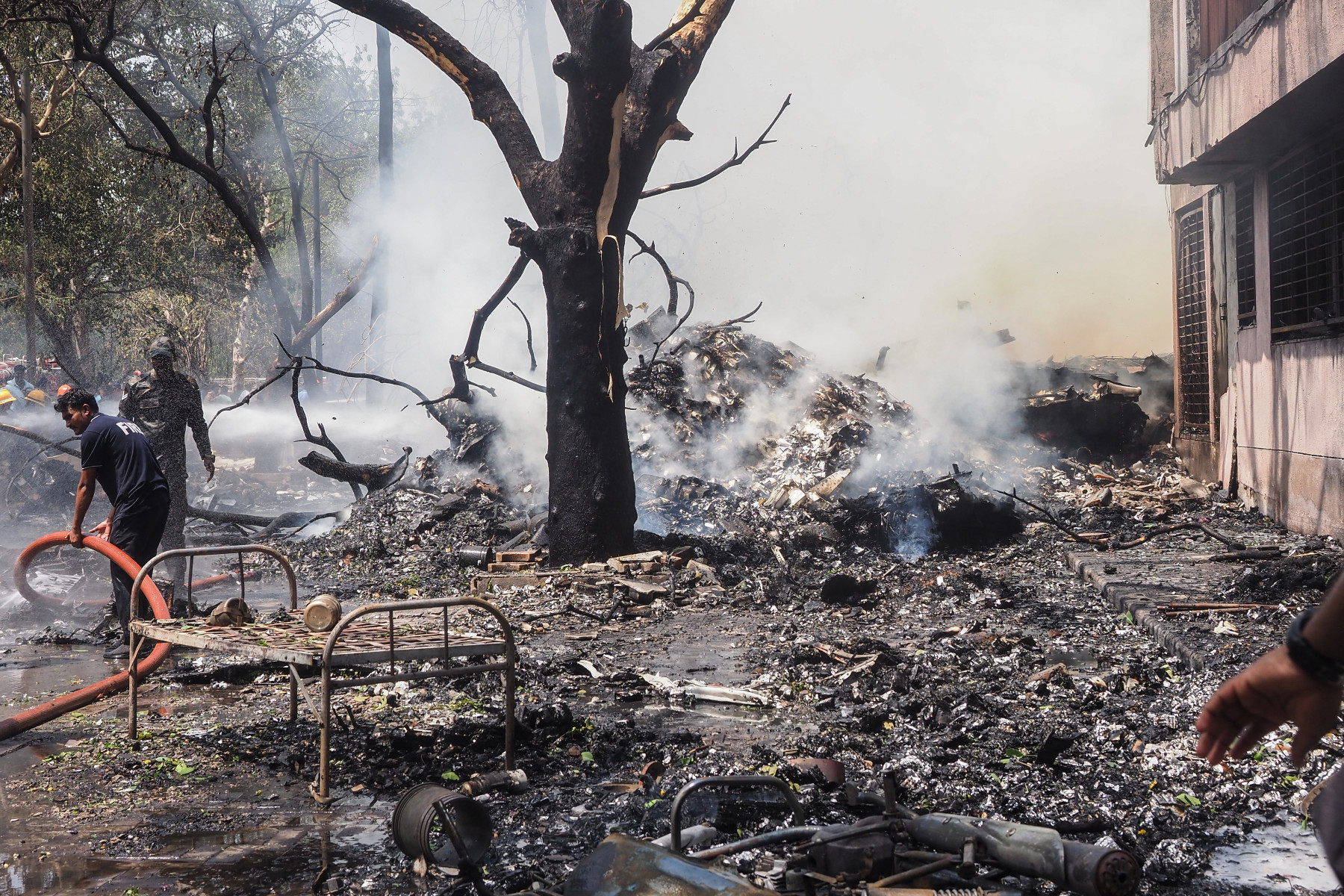 Bombeiros trabalham no local onde o voo 171 da Air India caiu em uma área residencial perto do aeroporto de Ahmedabad, em 12 de junho de 2025. O avião de passageiros com destino a Londres caiu em 12 de junho na cidade de Ahmedabad, no oeste da Índia, com 242 pessoas a bordo, disseram autoridades da aviação, no que a companhia aérea chamou de 