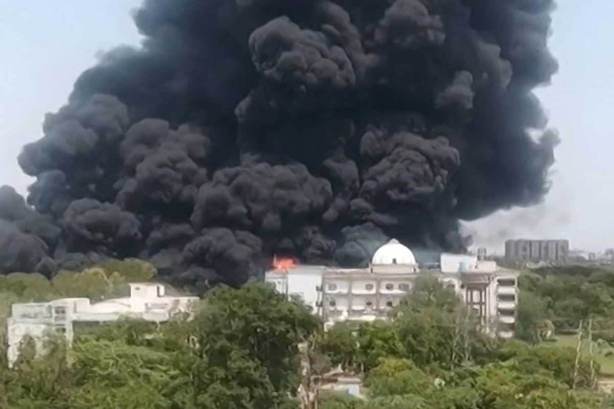 Esta captura de tela de um vídeo da UGC mostra uma densa fumaça preta subindo de uma área residencial após a queda do voo 171 da Air India em Ahmedabad, em 12 de junho de 2025. Equipes de resgate com cães farejadores vasculharam o local do acidente em 13 de junho do jato de passageiros com destino a Londres, que atingiu uma área residencial da cidade de Ahmedabad, na Índia, matando pelo menos 265 pessoas a bordo e no solo. (Foto de Vijay Patani / AFP)