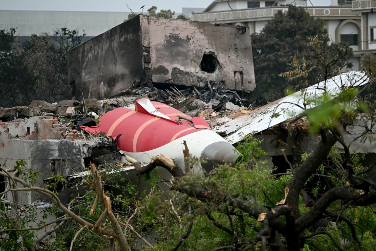 Os destroços do voo 171 da Air India são fotografados após a queda em uma área residencial perto do aeroporto de Ahmedabad, em 13 de junho de 2025. Equipes de resgate com cães farejadores vasculharam o local do acidente, em 13 de junho, de um jato de passageiros com destino a Londres que se chocou contra uma área residencial da cidade de Ahmedabad, na Índia, matando pelo menos 265 pessoas a bordo e em solo. (Foto de Punit PARANJPE / AFP)
