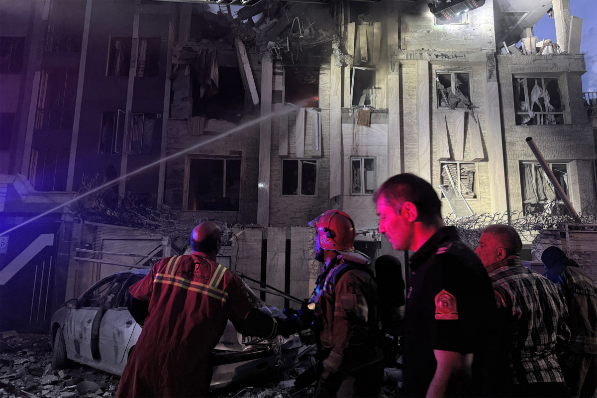 Equipes de emergência se reúnem em frente a um prédio atingido por um ataque israelense em Teerã em 13 de junho de 2025. Israel atingiu cerca de 100 alvos no Irã em 13 de junho, incluindo instalações nucleares e centros de comando militar, matando figuras importantes, como o chefe das Forças Armadas e importantes cientistas nucleares. (Foto de MEGHDAD MADADI / TASNIM NEWS / AFP) ( AFP) Equipes de emergência se reúnem em frente a um prédio atingido por um ataque israelense em Teerã em 13 de junho de 2025. Israel atingiu cerca de 100 alvos no Irã em 13 de junho, incluindo instalações nucleares e centros de comando militar, matando figuras importantes, como o chefe das Forças Armadas e importantes cientistas nucleares. (Foto de MEGHDAD MADADI / TASNIM NEWS / AFP)/ AFP