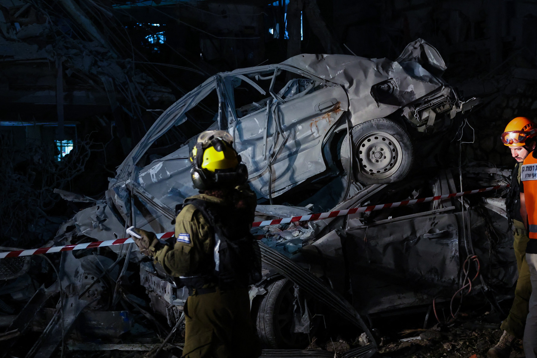  Membros das forças de segurança israelenses inspecionam um local atingido por um míssil disparado do Irã, em Ramat Gan, nos arredores de Tel Aviv, em 13 de junho de 2025. O Irã disparou uma saraivada de mísseis balísticos contra Israel em um contra-ataque na sexta-feira 