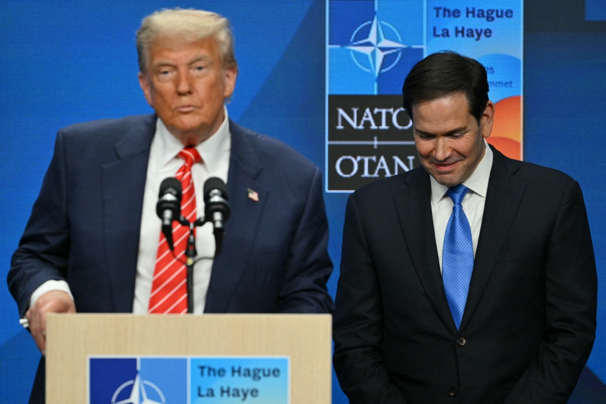 O secretário de Estado dos EUA, Marco Rubio (à direita), reage enquanto o presidente dos EUA, Donald Trump, discursa em uma coletiva de imprensa durante uma cúpula de chefes de Estado e de governo da Organização do Tratado do Atlântico Norte (OTAN) em Haia, em 25 de junho de 2025. (Foto de NICOLAS TUCAT / AFP)