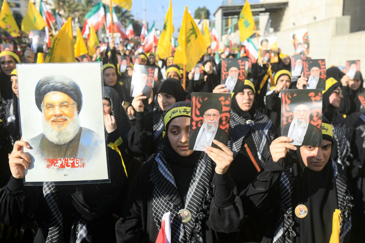 Apoiadores do Hezbollah libanês agitam bandeiras e seguram fotos de seu líder assassinado, Hassan Nasrallah, e do líder supremo do Irã, aiatolá Ali Khamenei, durante um comício em frente à Embaixada do Irã nos subúrbios ao sul de Beirute, para celebrar um cessar-fogo entre Israel e o Irã, em 25 de junho de 2025. O principal órgão de segurança do Irã afirmou, em 24 de junho, que as forças da República Islâmica 