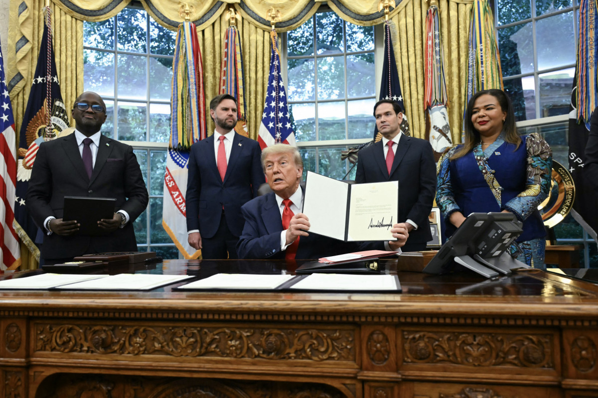 O presidente dos EUA, Donald Trump, segura uma carta endereçada ao presidente congolês Felix Tshisekedi parabenizando-o pelo acordo de paz com Ruanda durante uma reunião com a ministra das Relações Exteriores da República Democrática do Congo, Thérèse Kayikwamba Wagner, e o ministro das Relações Exteriores de Ruanda, Olivier Nduhungirehe (Foto: ANDREW CABALLERO-REYNOLDS / AFP) O presidente dos EUA, Donald Trump, segura uma carta endereçada ao presidente congolês Felix Tshisekedi parabenizando-o pelo acordo de paz com Ruanda durante uma reunião com a ministra das Relações Exteriores da República Democrática do Congo, Thérèse Kayikwamba Wagner, e o ministro das Relações Exteriores de Ruanda, Olivier Nduhungirehe/Foto: ANDREW CABALLERO-REYNOLDS / AFP