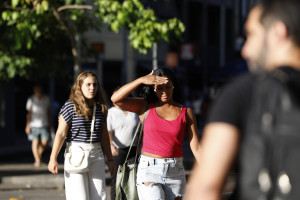 Pessoas se protegem do sol na região central da cidade durante onda de calor 