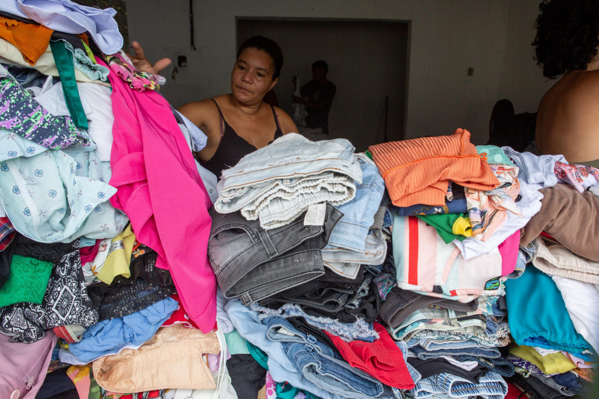 Patrícia escolhendo novas roupas entre as doações