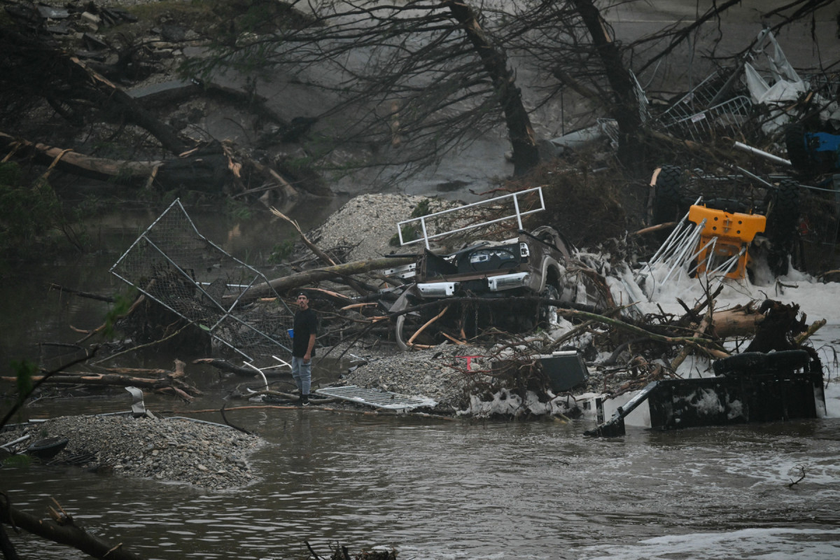  A member of the public stands next to overturned vehicles and broken trees after flooding caused by a flash flood at the Guadalupe River in Kerrville, Texas, on July 5, 2025. Rescuers were desperately searching for at least 20 girls missing from a riverside summer camp, officials said on July 5, after torrential rains caused a 