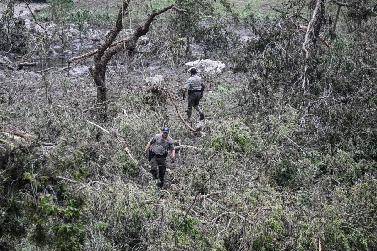Membros de um grupo de guardas florestais do Texas procuram pessoas desaparecidas no Rio Guadalupe, em Kerrville, Texas, em 6 de julho de 2025, após graves inundações repentinas ocorridas durante o feriado de 4 de julho. Equipes de resgate no Texas correram contra o tempo no domingo para encontrar dezenas de pessoas desaparecidas, incluindo crianças, arrastadas por inundações repentinas que mataram pelo menos 78 pessoas, enquanto meteorologistas alertavam para novos dilúvios. Texanos locais uniram forças com autoridades de desastres para procurar durante a noite pelos desaparecidos, incluindo 27 meninas de um acampamento de verão cristão à beira do rio. O governador do Texas, Greg Abbott, disse que o Acampamento Mystic, às margens do Rio Guadalupe, onde cerca de 750 meninas estavam hospedadas quando as águas atingiram o local, foi Membros de um grupo de guardas florestais do Texas procuram pessoas desaparecidas no Rio Guadalupe, em Kerrville, Texas, em 6 de julho de 2025, após graves inundações repentinas ocorridas durante o feriado de 4 de julho. Equipes de resgate no Texas correram contra o tempo no domingo para encontrar dezenas de pessoas desaparecidas, incluindo crianças, arrastadas por inundações repentinas que mataram pelo menos 78 pessoas, enquanto meteorologistas alertavam para novos dilúvios. Texanos locais uniram forças com autoridades de desastres para procurar durante a noite pelos desaparecidos, incluindo 27 meninas de um acampamento de verão cristão à beira do rio. O governador do Texas, Greg Abbott, disse que o Acampamento Mystic, às margens do Rio Guadalupe, onde cerca de 750 meninas estavam hospedadas quando as águas atingiram o local, foi