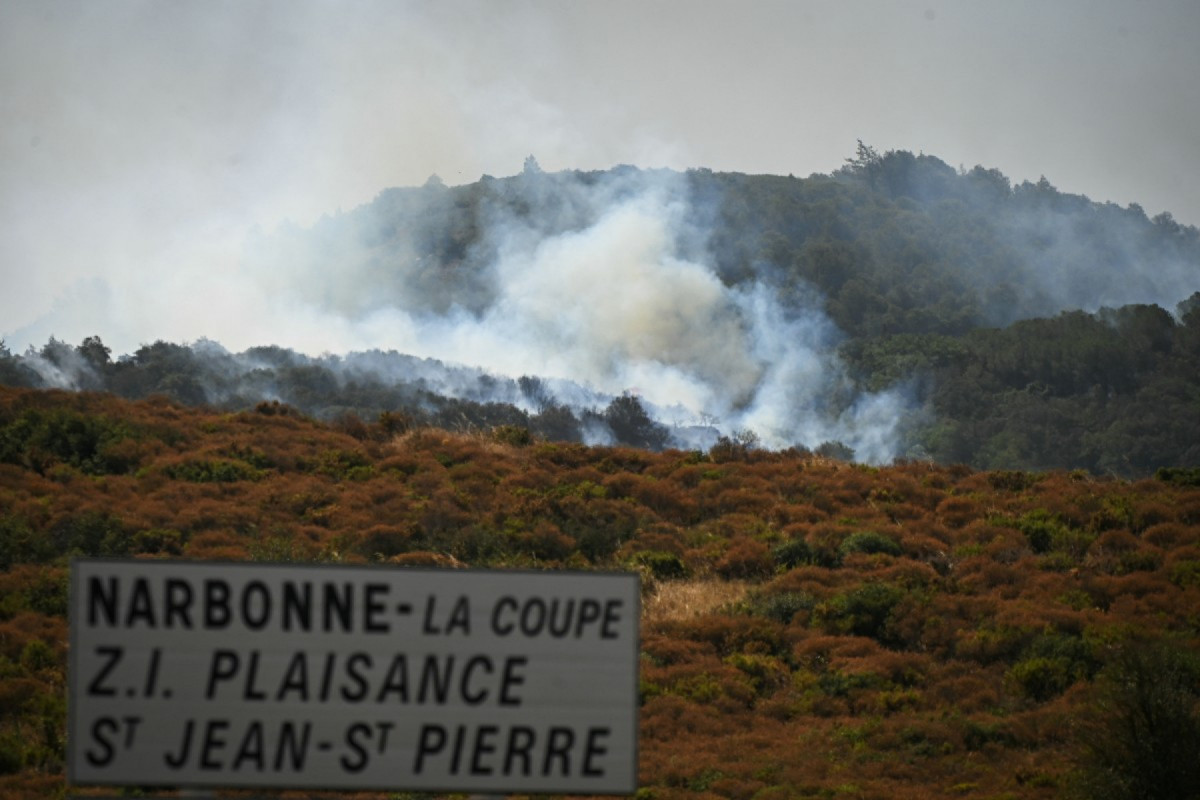 Fumaça sobe de um incêndio florestal perto do bairro de Aussieres, perto da cidade de Narbonne, sudoeste da França, em 8 de julho de 2025. (Foto de Matthieu RONDEL / AFP)