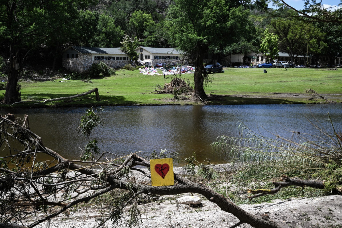 Um coração partido pintado é visto perto do Acampamento Mystic, ao longo do Rio Guadalupe, em Hunt, Texas, em 8 de julho de 2025, após graves inundações repentinas no feriado de 4 de julho.  (Foto de RONALDO SCHEMIDT / AFP)