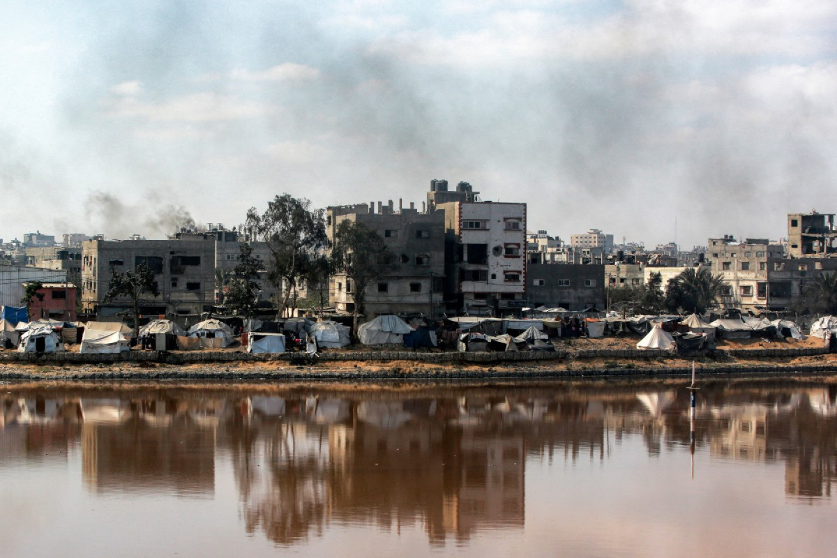 Acampamentos abrigando palestinos deslocados pelo conflito são montados perto do lago de coleta de águas residuais Sheikh Radwan, que está quase cheio, na Cidade de Gaza, em 14 de julho de 2025. (Foto de Bashar TALEB / AFP)