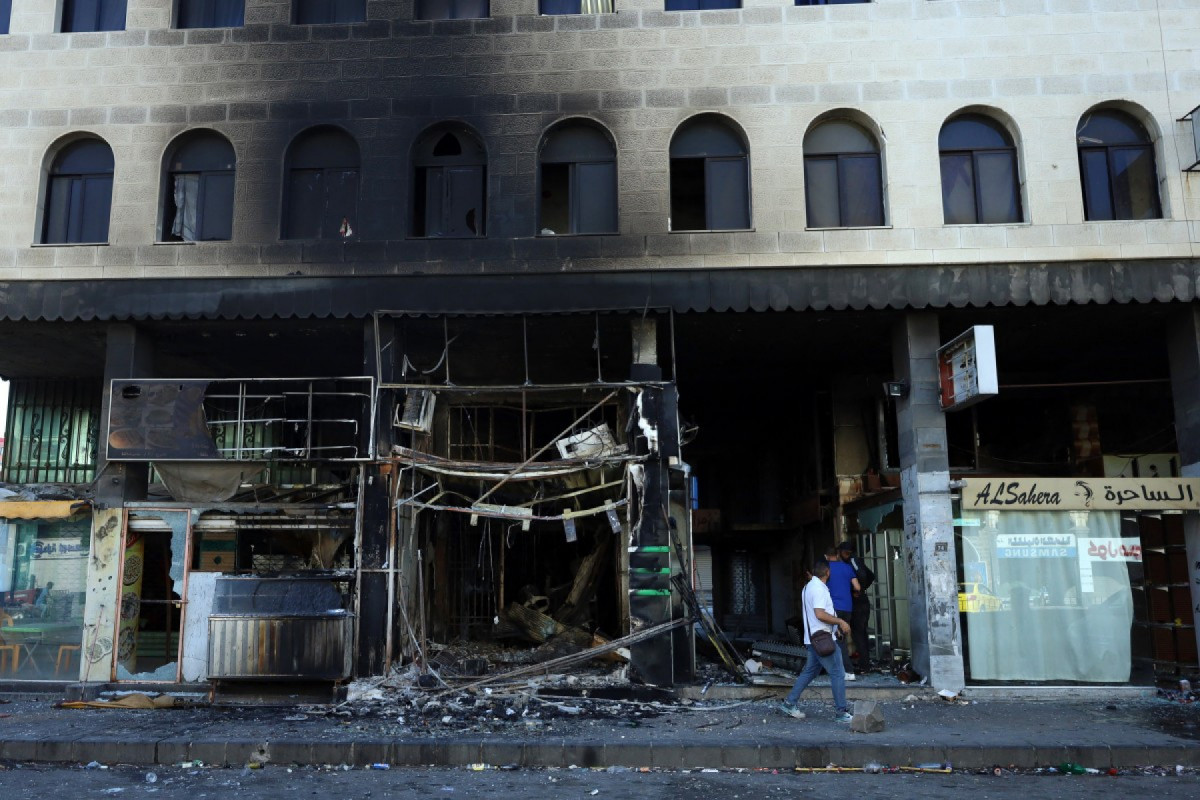  People assess the damage in a building after Syrian government forces pulled out of the southern Sweida governorate, on July 17, 2025. The Druze heartland Sweida has been gripped by deadly sectarian bloodshed since July 13, with hundreds reportedly killed in clashes pitting Druze fighters against Sunni Bedouin tribes and the army and its allies. 