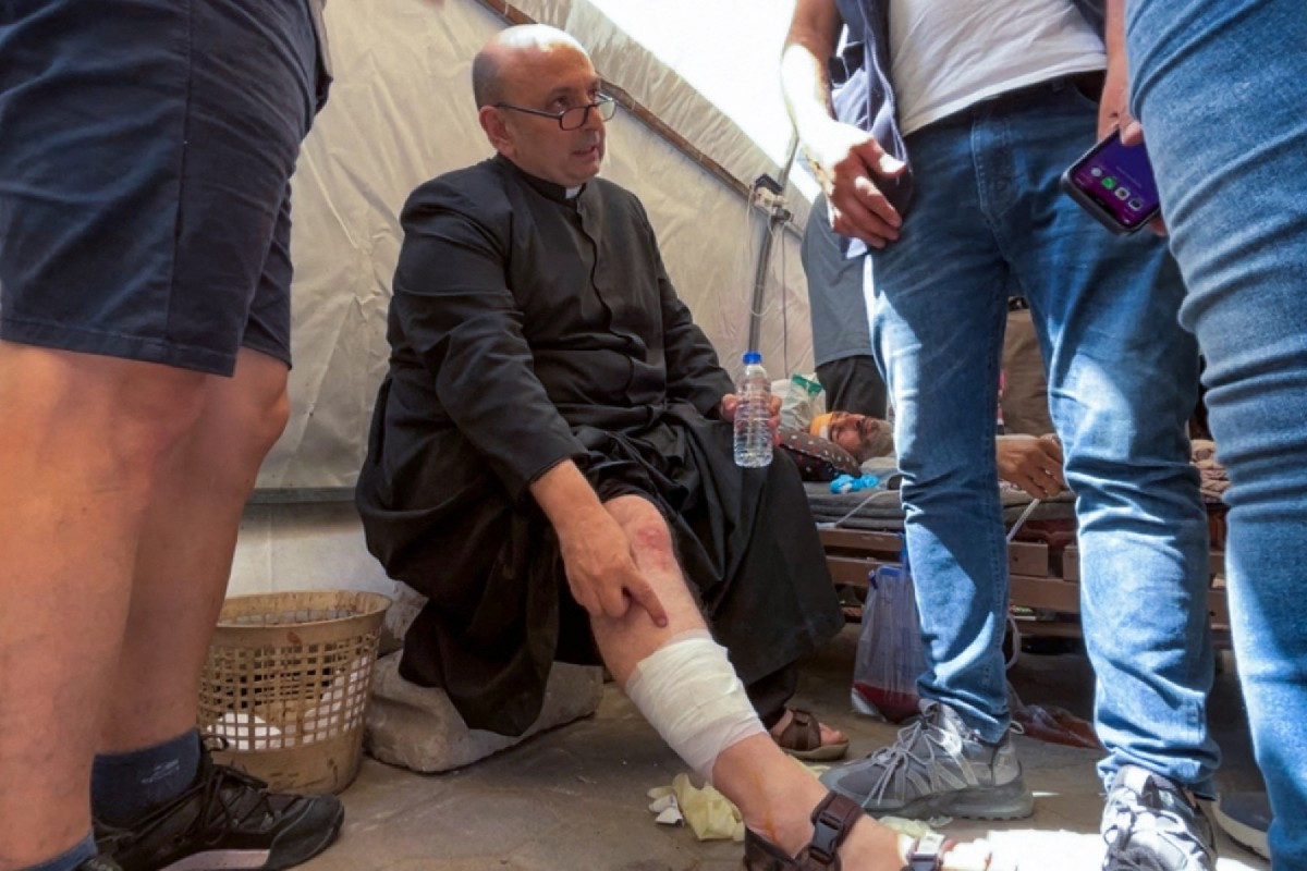 Pároco da Igreja da Sagrada Família na Cidade de Gaza, Pe. Gabriel Romanelli, recebe atendimento após ser ferido em um ataque israelense contra a igreja, no hospital Árabe Ahli, também conhecido como Batista, em 17 de julho de 2025. O Patriarcado Latino de Jerusalém informou que um ataque israelense contra a única igreja católica de Gaza matou duas pessoas e feriu várias em 17 de julho, incluindo o pároco, além de causar danos ao prédio. (Foto de Omar AL-QATTAA / AFP)/ AFP