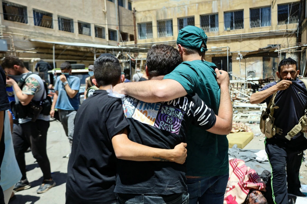  EDITORS NOTE: Graphic content / A health worker and other men walk amid the bodies of victims of the recent clashes between local Druze fighters and Bedouin tribes, laid out for identification in the yard of a hospital in Syria's southern city of Sweida on July 17, 2025. In the devastated Druze-majority city of Sweida, residents were shocked by the bodies littering the streets next to looted shops and burned homes following the withdrawal of Syrian government forces. 