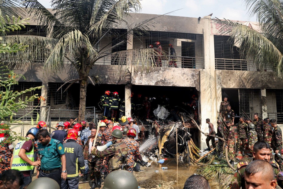 O corpo de bombeiros e a equipe de segurança de Bangladesh realizam uma operação de busca e salvamento após um jato de treinamento da Força Aérea ter caído em uma escola em Daca, em 21 de julho de 2025. Pelo menos 16 pessoas, a maioria estudantes, morreram em 21 de julho, quando um avião de treinamento da Força Aérea de Bangladesh caiu em um campus escolar na capital, Daca, informou o governo. (Foto de Abdul Goni / AFP)