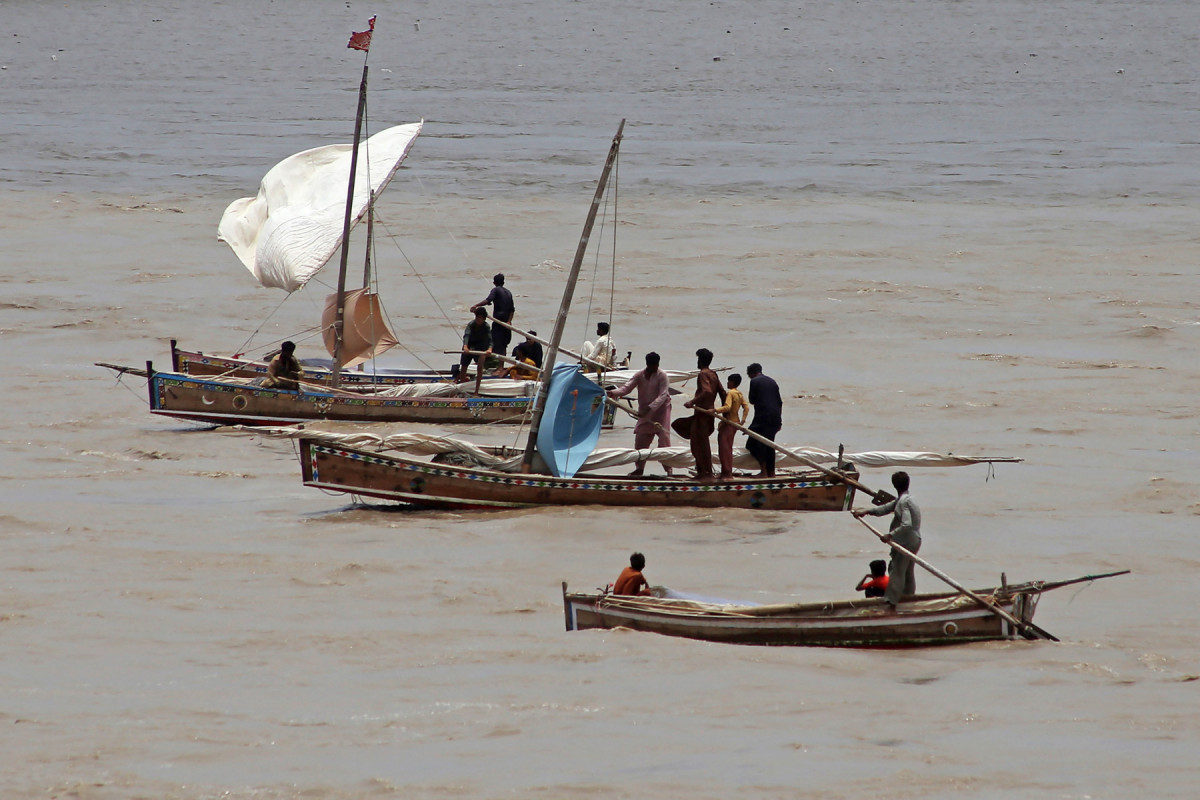Pescadores navegam em seus barcos com o aumento do nível das águas do rio Indo, na barragem de Kotri, em Hyderabad, em 22 de julho de 2025. A temporada de monções traz de 70% a 80% da precipitação anual para o sul da Ásia e vai do final de junho a setembro no Paquistão. As chuvas anuais são vitais para a agricultura, a segurança alimentar e o sustento de milhões de agricultores, mas também trazem destruição. (Foto de Akram SHAHID / AFP)