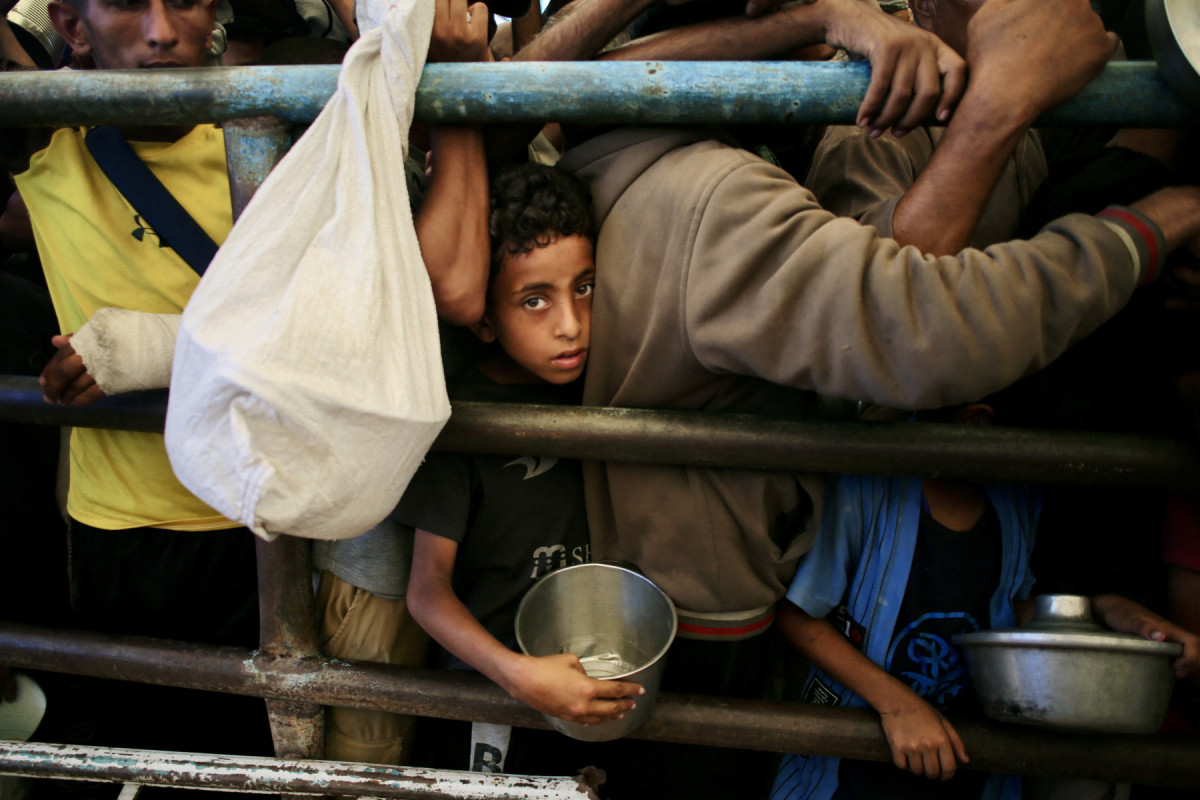 Um menino palestino aguarda uma refeição em uma cozinha beneficente na área de Mawasi, em Khan Yunis, no sul da Faixa de Gaza, em 22 de julho de 2025. O chefe do maior hospital de Gaza disse que 21 crianças morreram de desnutrição e fome no território palestino nos últimos três dias, em meio a um ataque devastador das forças israelenses. (Foto: AFP) ( AFP) Um menino palestino aguarda uma refeição em uma cozinha beneficente na área de Mawasi, em Khan Yunis, no sul da Faixa de Gaza, em 22 de julho de 2025. O chefe do maior hospital de Gaza disse que 21 crianças morreram de desnutrição e fome no território palestino nos últimos três dias, em meio a um ataque devastador das forças israelenses. (Foto: AFP)/ AFP