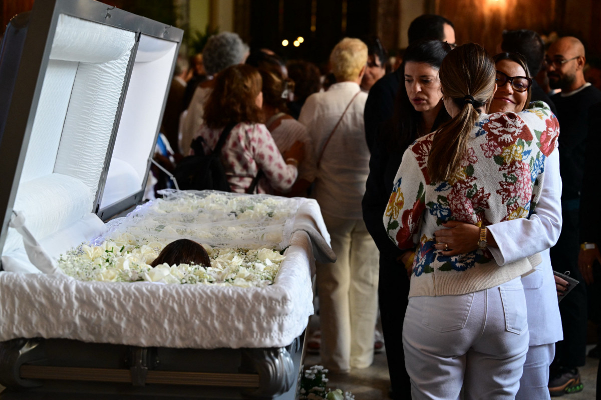 A primeira-dama do Brasil, Janja da Silva (à direita), conforta familiares da cantora e atriz brasileira Preta Gil durante seu funeral no Theatro Municipal do Rio de Janeiro, em 25 de julho de 2025. Petra Gil, filha do lendário músico Gilberto Gil, morreu em 20 de julho em Nova York, EUA, aos 50 anos, após lutar contra um câncer. (Foto de Pablo PORCIUNCULA / AFP)