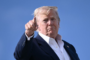 O presidente dos EUA, Donald Trump, aponta ao embarcar no Força Aérea Um na Base Aérea da RAF de Lossiemouth, nordeste da Escócia, em 29 de julho de 2025, no final de sua viagem à Escócia. (Foto de Brendan SMIALOWSKI / AFP)