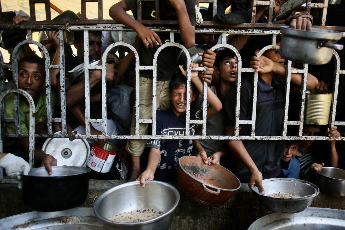 Palestinian children wait for a meal at a charity kitchen in the Mawasi area of Khan Yunis in the southern Gaza Strip on July 22, 2025. The head of Gaza's largest hospital said 21 children have died due to malnutrition and starvation in the Palestinian territory in the past three days, amid a devastating assault by Israeli forces. (Photo by AFP) ( AFP) Palestinian children wait for a meal at a charity kitchen in the Mawasi area of Khan Yunis in the southern Gaza Strip on July 22, 2025. The head of Gaza's largest hospital said 21 children have died due to malnutrition and starvation in the Palestinian territory in the past three days, amid a devastating assault by Israeli forces. (Photo by AFP)/ AFP