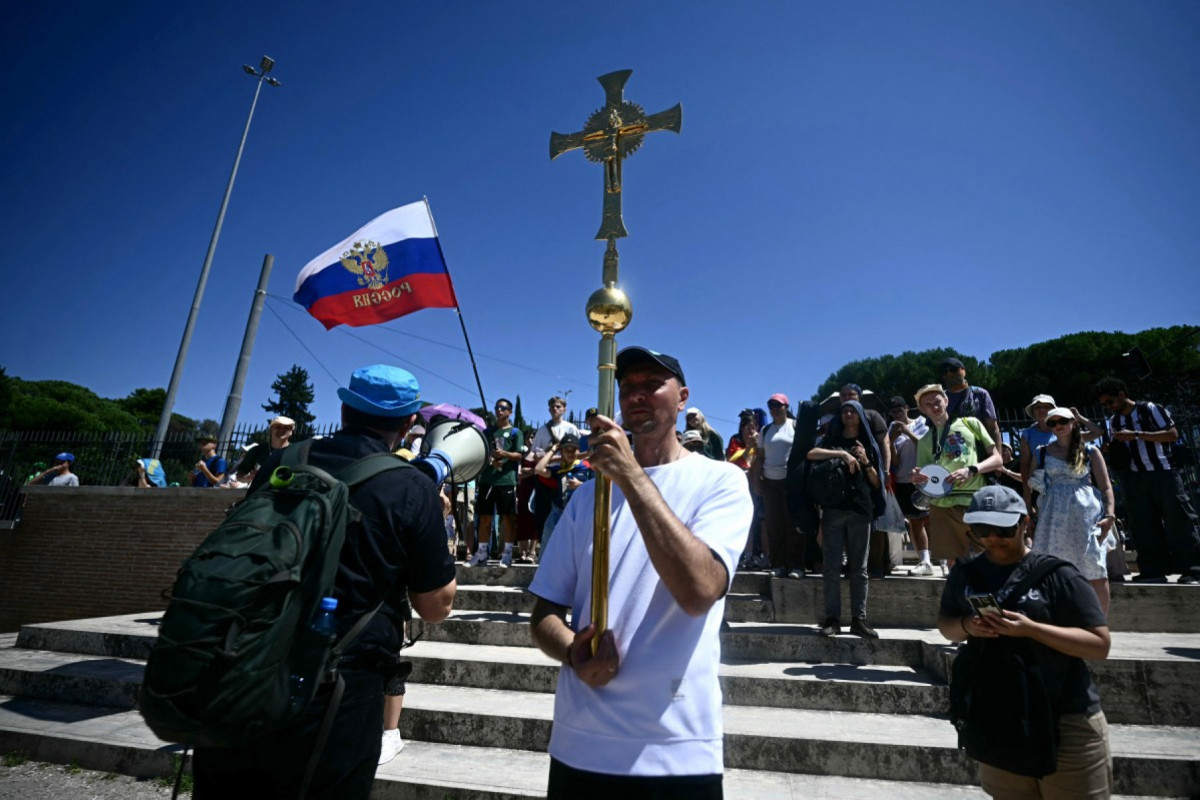 A Russian faithful holding a crucifix arrives to attend in a mass confession event to receive the sacrament of reconciliation, held under tents at the Circo Maximus as part of the Youth Jubilee in Rome, on August 1, 2025. About 1 million people are expected to attend the final Mass on August 3, 2025, with Pope Leo XIV in Rome's Tor Vergata neighbourhood, just over two months after he became the head of the Catholic Church and the first American Pope. (Photo by Filippo MONTEFORTE / AFP) ( Filippo Monteforte/AFP) A Russian faithful holding a crucifix arrives to attend in a mass confession event to receive the sacrament of reconciliation, held under tents at the Circo Maximus as part of the Youth Jubilee in Rome, on August 1, 2025. About 1 million people are expected to attend the final Mass on August 3, 2025, with Pope Leo XIV in Rome's Tor Vergata neighbourhood, just over two months after he became the head of the Catholic Church and the first American Pope. (Photo by Filippo MONTEFORTE / AFP)/ Filippo Monteforte/AFP