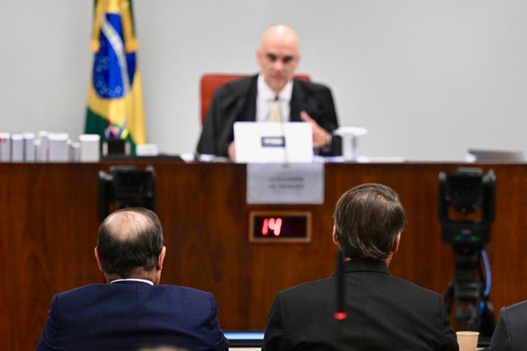 O ex-presidente brasileiro Jair Bolsonaro (à direita), sentado ao lado de seu advogado Celso Villardi (à esquerda), depõe perante o ministro Alexandre de Moraes, durante sessão no STF que julga a participação dos acusados na tentativa de golpe de Estado em 8 de janeiro de 2023
