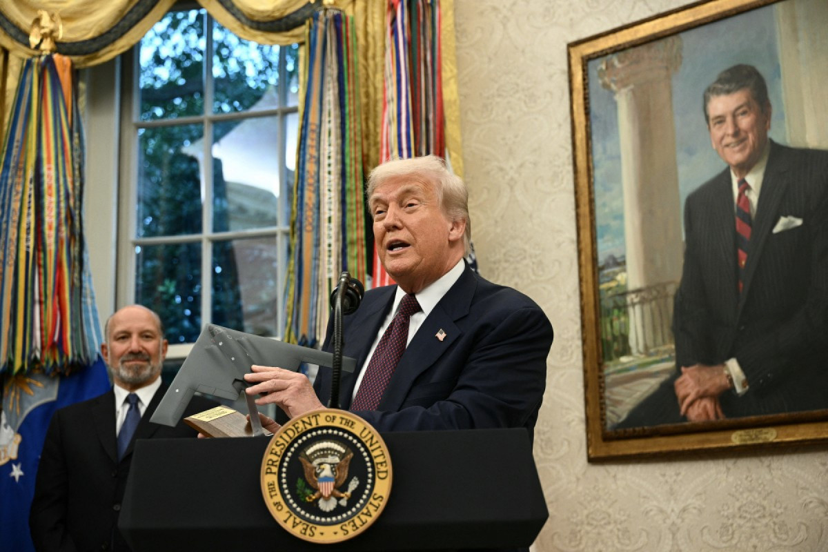 O presidente dos EUA, Donald Trump, segura um modelo de uma nova versão do bombardeiro stealth B-2 enquanto discursa no Salão Oval da Casa Branca, em Washington, D.C., em 6 de agosto de 2025, após anunciar que a Apple investirá mais US$ 100 bilhões nos Estados Unidos, elevando seu compromisso total para US$ 600 bilhões nos próximos quatro anos. (Foto de Brendan SMIALOWSKI / AFP)/ AFP