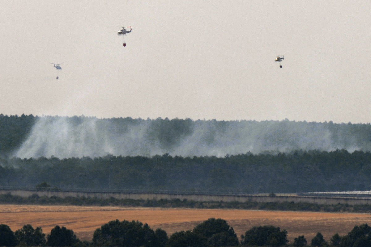 Helicópteros combatem um incêndio florestal em Guardo, província de Palência, em 18 de agosto de 2025. Milhares de bombeiros, apoiados por militares e aeronaves de bombardeio de água, combateram hoje dezenas de incêndios florestais em toda a Espanha e Portugal, com o número de mortos aumentando para seis desde o início dos surtos. Na Espanha, os incêndios florestais queimaram o equivalente a quase meio milhão de campos de futebol este ano, estabelecendo um novo recorde, de acordo com dados divulgados hoje pelo Sistema Europeu de Informação sobre Incêndios Florestais (Effis). Os incêndios de 2025 já queimaram mais de 343.000 hectares (848.000 acres), superando o recorde anterior para o período, de 306.000 hectares, estabelecido em 2022. (Foto de Cesar Manso / AFP)